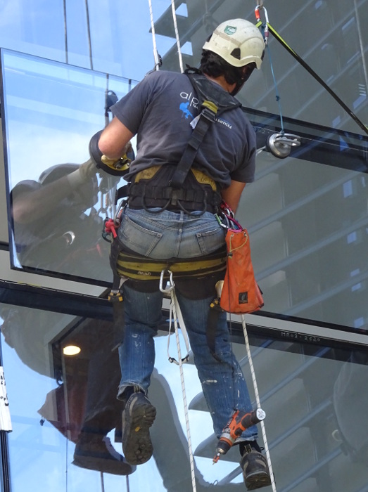 Pose vitrage de mur rideau en hauteur en des techniques de levage cordiste