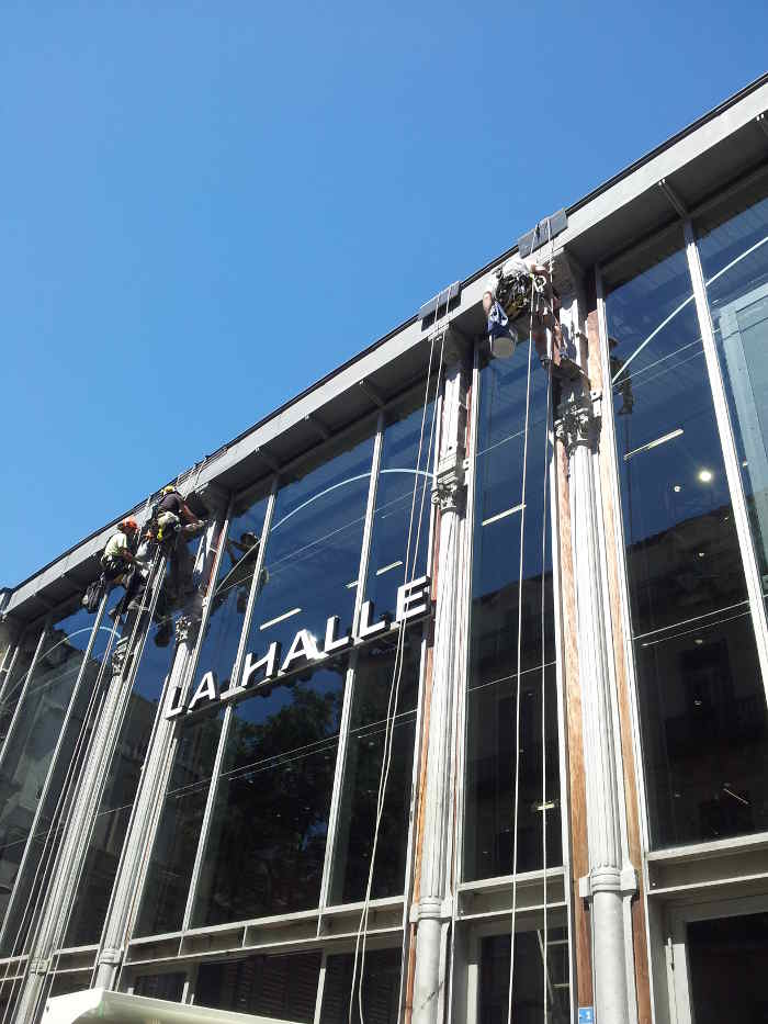 Traitement et mise en peinture de colonnes en faade par des techniciens cordistes