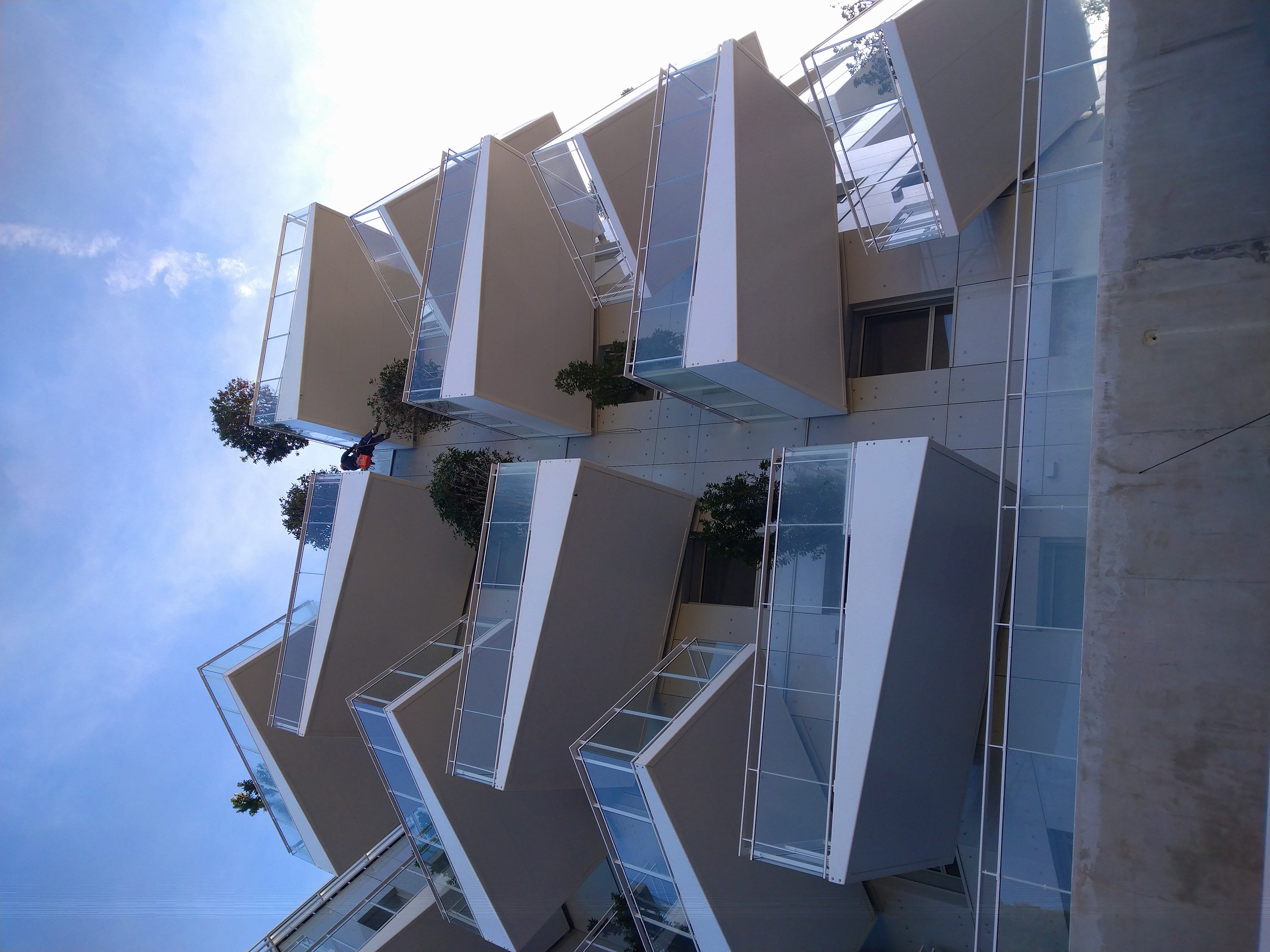Projection de peinture sur les balcons en acier de cet immeuble. Nos cordistes du bâtiment adaptent leur technique de peinture aux différents matériaux.